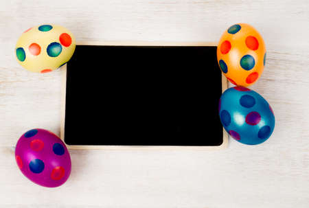 Black board with colorful dotted easter eggsの写真素材