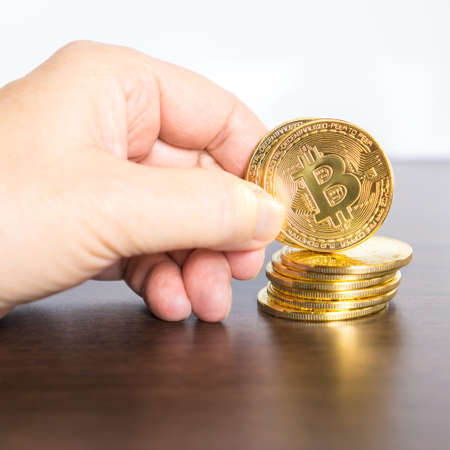 Hand holding a bitcoinの写真素材