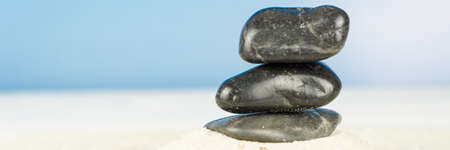 Three black stones on the beachの写真素材
