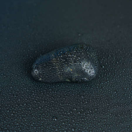 Stone with water drops on black backgroundの写真素材