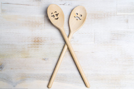 Two wooden spoon with smiling faces on wooden backgroundの写真素材
