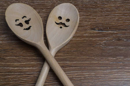 Two wooden spoon with smiling faces on wooden backgroundの写真素材