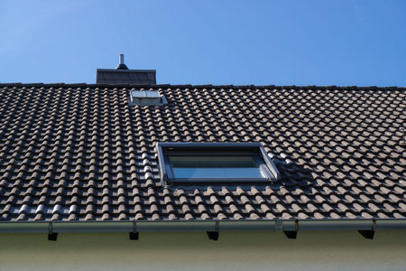 Roof with window, blue sky background