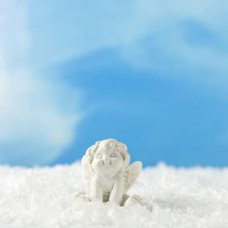 Little angel sitting in the snow, squareの写真素材