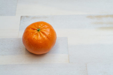 One mandarin on wooden background