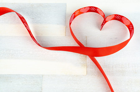 Heart of red bow on wooden background, copy spaceの写真素材
