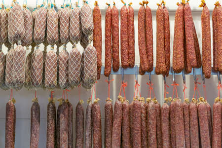 Many dried sausages in a butcher shopの写真素材