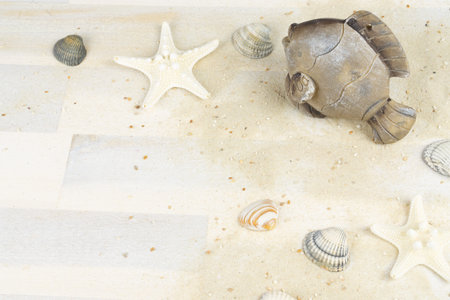 Maritime background with sand, shells and a fish, copy space