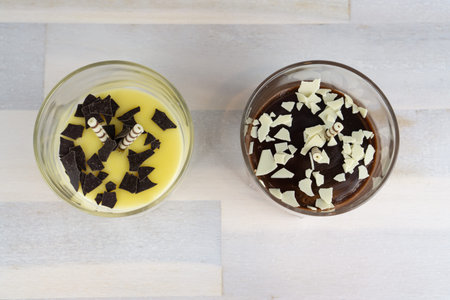 A glass with vanilla pudding and one with chocolate pudding