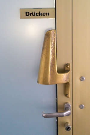 Door with handle and a sign with the german word for pressの写真素材