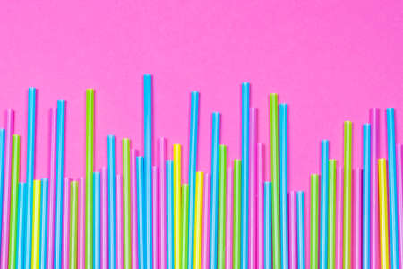 Colorful plastic straws on pink background, copy spaceの写真素材