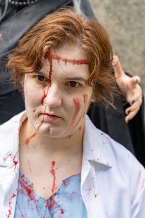 Young woman with blood on her faceの写真素材