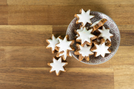 A cup with christmas biscuits on a wooden table and copy space, top view
