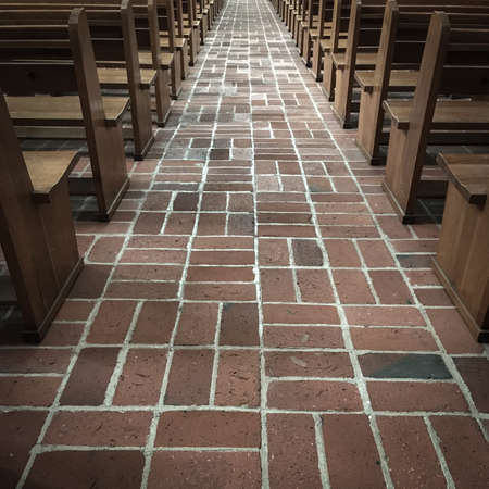 Central corridor with red bricks and benches on the sidesの写真素材