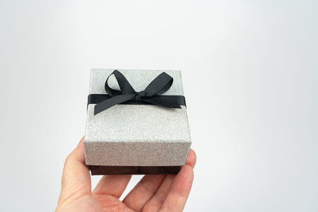 Present in a silver box with black bow, white background and copy space