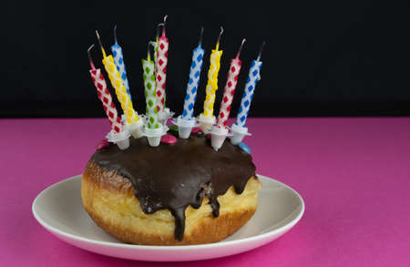 Blowed out birthday candles on a small birthday cake, streamers in the black and pinkの写真素材