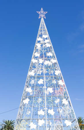 Large metal Christmas tree outside with a clear blue skyの写真素材