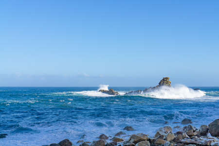 The rough Atlantic Ocean near Tenerife, Spain, strong waves break on the rocks in the waterの写真素材