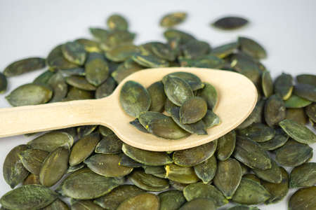 A wooden spoon with many pumpkin seedsの写真素材