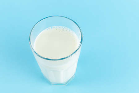 A glass of fresh milk on blue background, copy spaceの写真素材