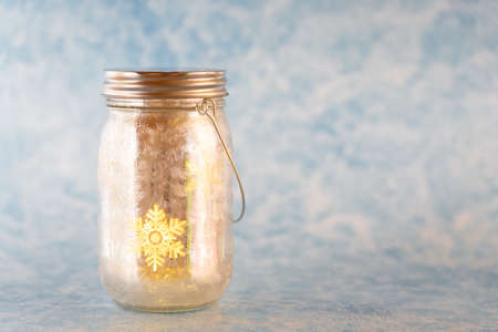 Christmas decoration with a golden shimmering glass with a shining snowflake, copy spaceの写真素材