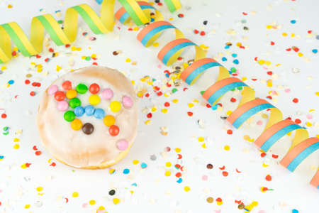 Delicious birthday cake with confetti and streamers, white background with copy spaceの写真素材