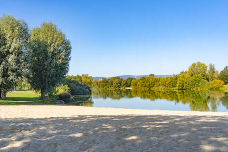 Bathing lake with a small sandy beach in the Fuldaaue of Kassel, Germanyの写真素材