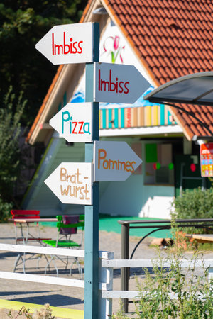 Colorful information sign with the German words for diner, pizza, fries, bratwurst