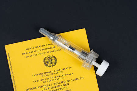 Vaccination against virus with syringe and vaccination card, black background and copy space, Kassel, Germany, November, 14th, 2020のeditorial素材