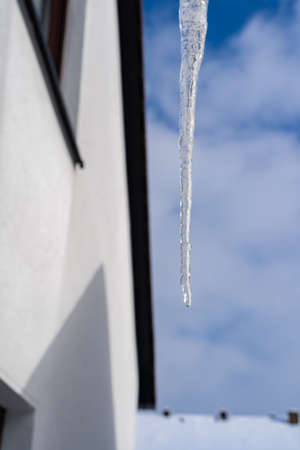 Single icicle with a water droplet on top, blue sky and copy spaceの写真素材
