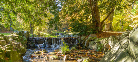 Small waterfall of a stream in a park in autumnの写真素材