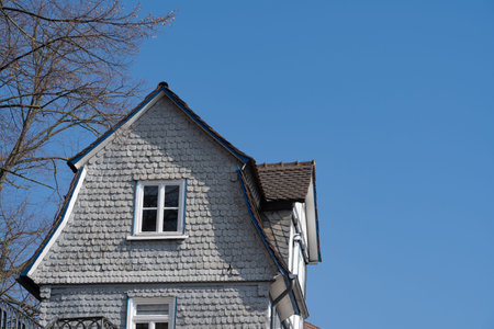 Old house with gray shingles on the facade, blue sky and copy spaceの写真素材
