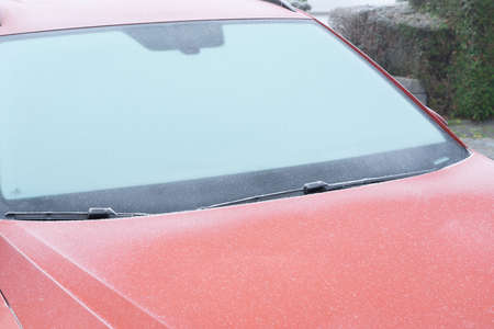 Red car with a frozen windowの写真素材