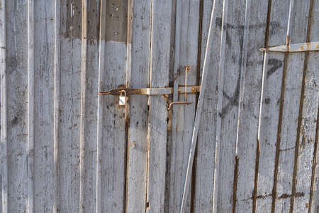 Old weathered wooden gate with bolt and lockの写真素材