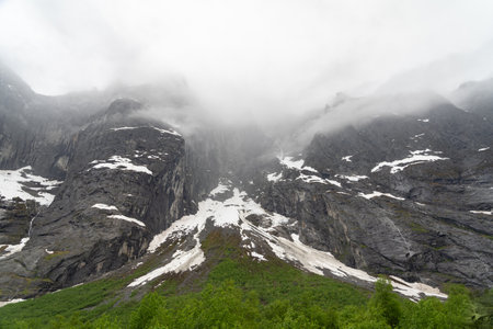 Cloud-covered Troll Wall above the Rauma River near Andalsnes, Norwayの写真素材
