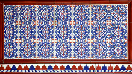 A ceramic tile mosaic with blue and red floral patterns. These designs are typically found on the...