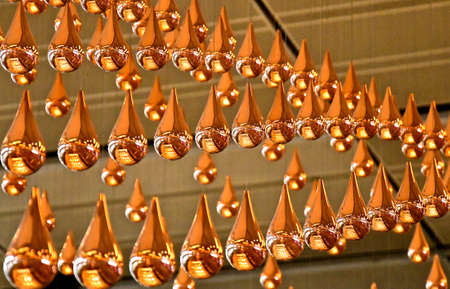 Close up view of suspended bronze droplets which are part of a dynamic kinetic rain art installationの写真素材