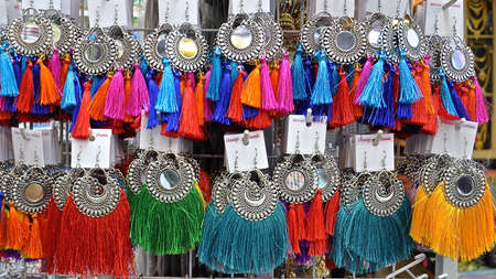A shop display of colourful earrings with bright cotton tassles.の写真素材