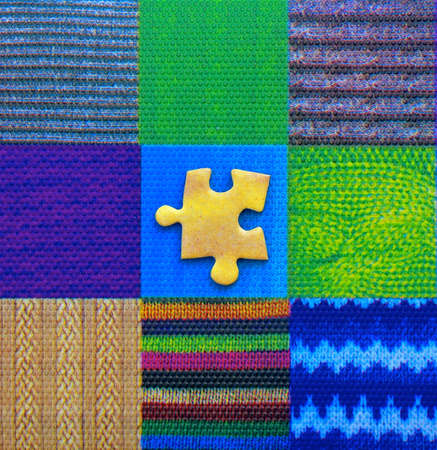 A yellow jigsaw piece on a grid mosaic of colourful, textured geometric patterns.の写真素材
