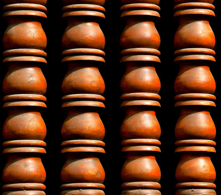 A close up view of terracotta urns in a column formation to create an open window barrier. This is...