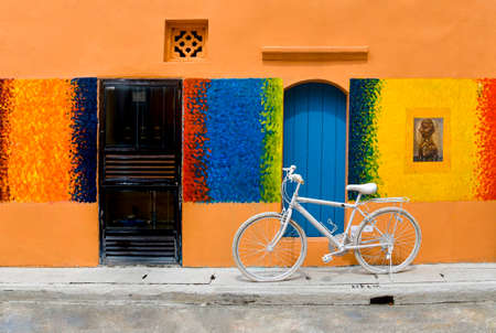 Renovated building painted with a colourful mural with a vintage bicycle outside.の写真素材
