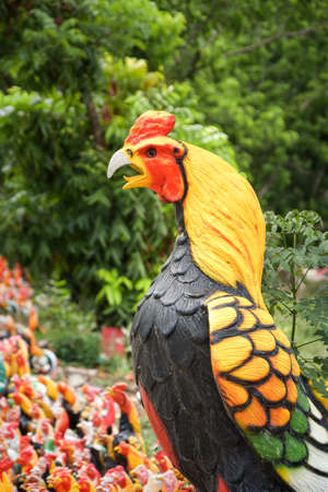 A side profile of a large pottery rooster in a buddhist temple complex in Thailand.の写真素材