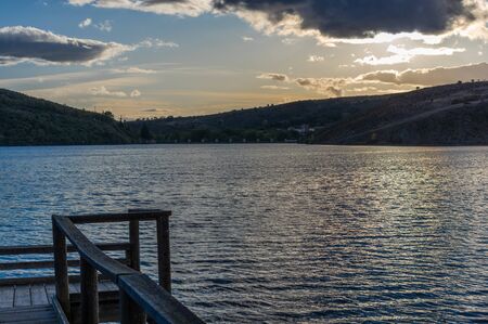 Views during the beautiful sunset on the dock for fishing of the Selga de Ordas reservoir in Leon, Spainの写真素材