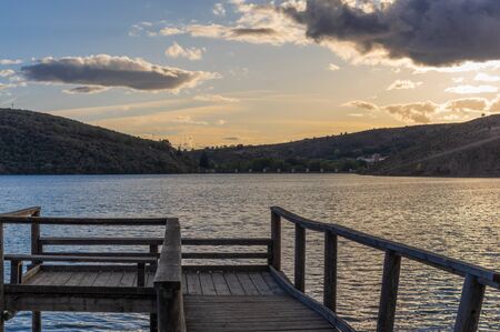Views during the beautiful sunset on the dock for fishing of the Selga de Ordas reservoir in Leon, Spainの写真素材