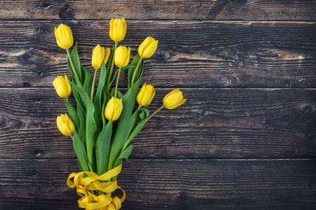 Bouquet of yellow tulips on wooden background, for congratulations. Copy space.の写真素材