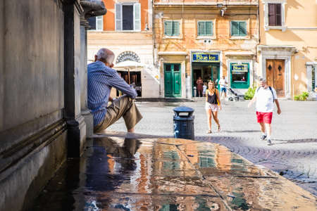 Rome, Italy; July 22nd 2018: Old man seated in steps of fontana di Santa Maria in Trastevereのeditorial素材