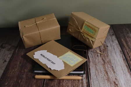 Gift box and note book on the wooden table with copy space. World Post Day concept