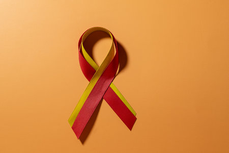 Red and yellow ribbon on orange background. Concept of Hepatitis Day.の写真素材