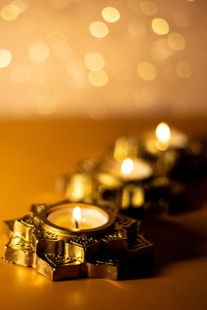 A close-up photograph of a glowing candles placed in a beautifully ornate, star-shaped golden...
