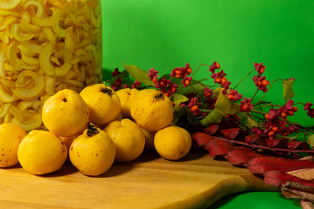 Autumn still life  with chaenomeles and berries on green background. Selective focusの写真素材
